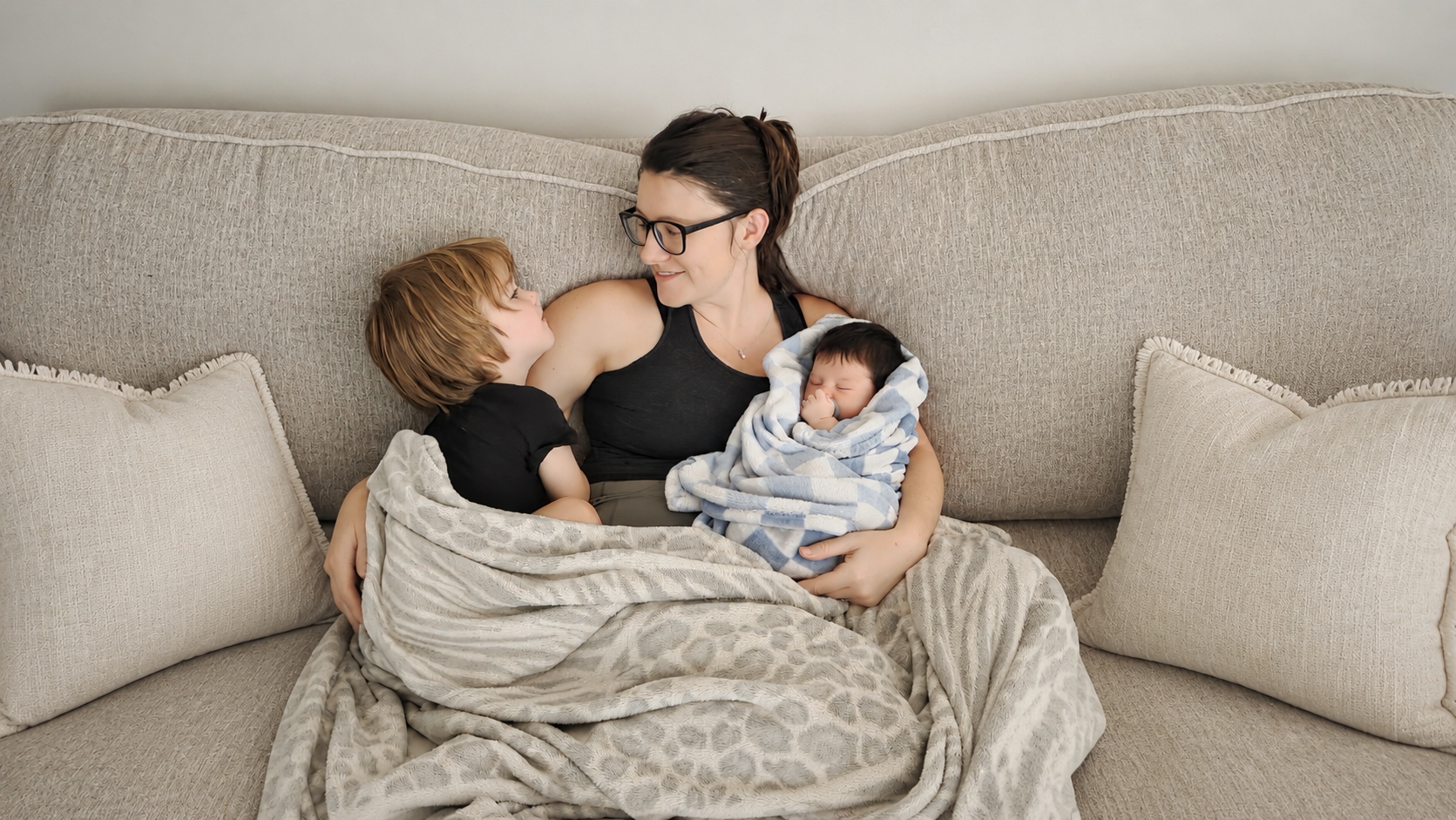 Courtney cuddling with her two boys on the couch